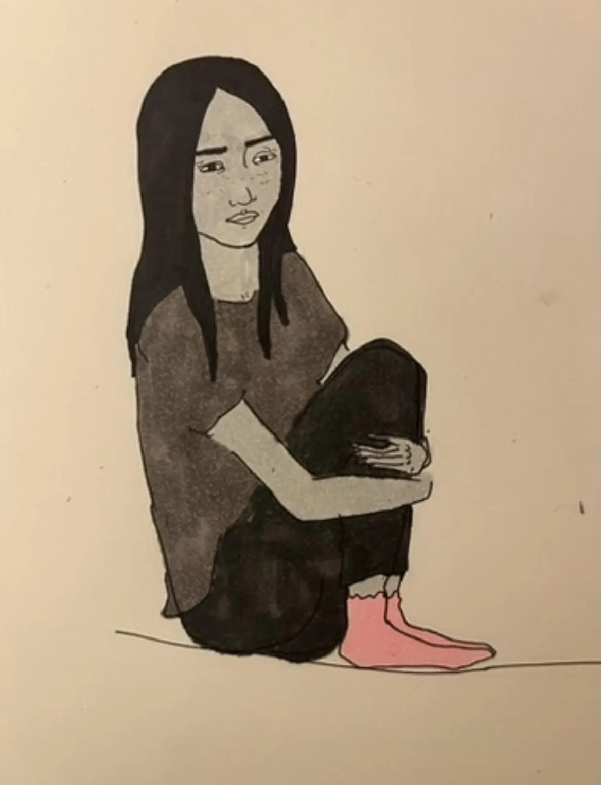 A drawing of a woman sitting on the floor, arms around her knees